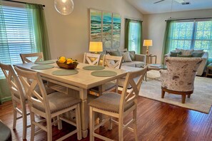 A dining area with a wooden table, chairs, and a bowl of fruit. - Pool & Hot Tub Access: True Blue Golf Resort Condo (Pawleys Island)