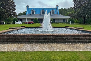Um edifício azul grande com uma fonte em frente.