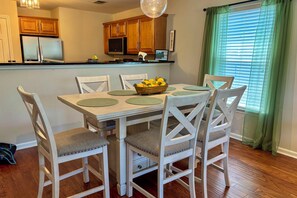 A dining area with a table set for four, surrounded by chairs with cushioned seats. - Pool & Hot Tub Access: True Blue Golf Resort Condo (Pawleys Island)