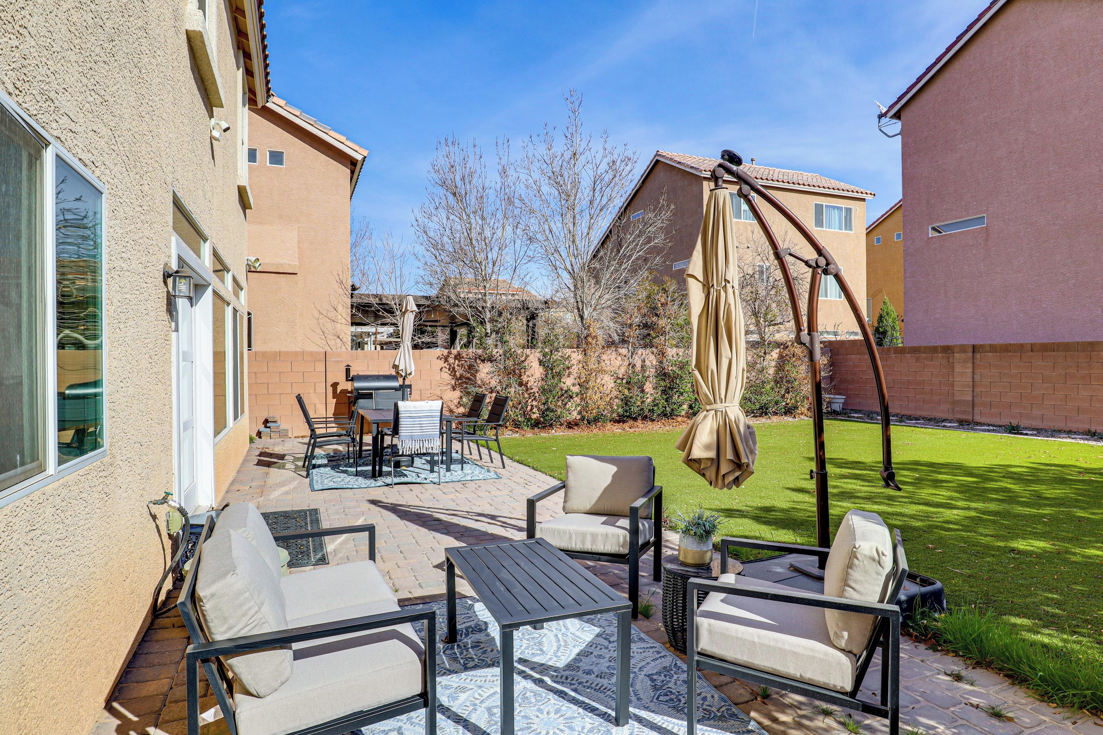 A patio with outdoor furniture, a grill, and a swing set.