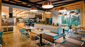 A modern restaurant with a central bar area, wooden ceiling beams, and large windows overlooking a forest. - Lovely (sta)caravan in Vabriga (Vabriga)