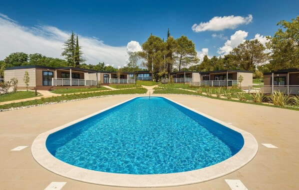 A rectangular swimming pool with a clear blue center, surrounded by a concrete deck. - Lovely (sta)caravan in Vabriga (Vabriga)