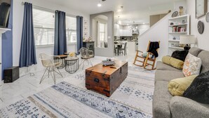 A living room with a sofa, a coffee table, and a dining area with chairs and a table. - 3 Mi to Randolph AFB: San Antonio Area Home (Universal City)