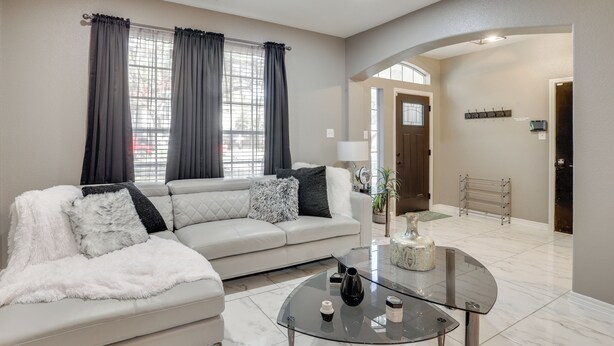 A modern living room with a white sofa, a glass coffee table, and a large window with curtains. - 3 Mi to Randolph AFB: San Antonio Area Home (Universal City)