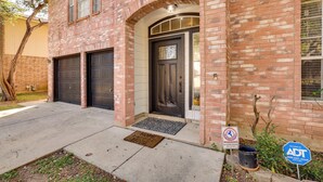 A two-story brick building with a dark brown front door, two garage doors, and a small porch area with a doormat. - 3 Mi to Randolph AFB: San Antonio Area Home (Universal City)