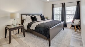 A bedroom with a bed, a nightstand, a chair, a ceiling fan, and a window with curtains. - 3 Mi to Randolph AFB: San Antonio Area Home (Universal City)