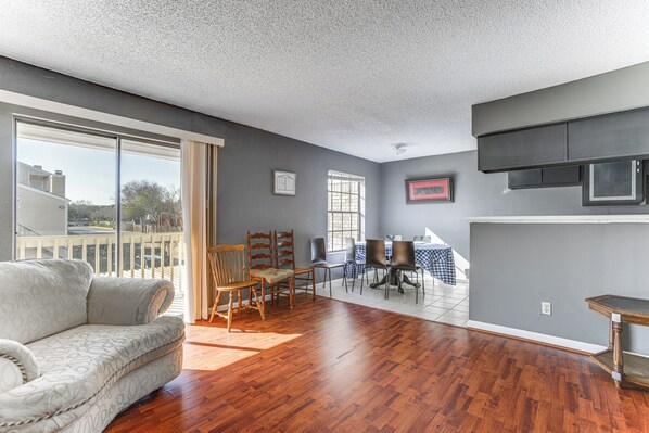 A spacious living area with a large window, a sofa, and a dining table with chairs. - 3 Mi to Houston Medical Center: Extended Stay (Houston)