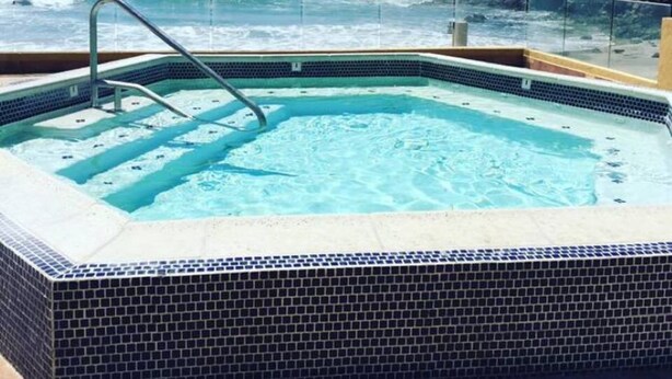 Ein Whirlpool mit freiem Blick auf den Ozean und die felsige Küstenlinie.