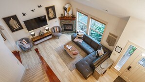 Una sala de estar amplia con chimenea, televisor grande y zona de estar confortable.