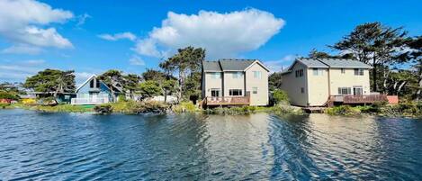 A waterfront property with multiple houses, a dock, and a clear blue sky.