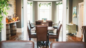 A dining area with a brick wall, wooden barrels, and a chandelier. - Modern, Spacious 4-Bedroom Home with Garden & Garage (Beachburg)
