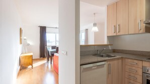 A modern kitchen with wooden cabinets, a stainless steel sink, and a built-in dishwasher. - Bright Apartment with Terrace and Parking in Santa Margarita (Roses)