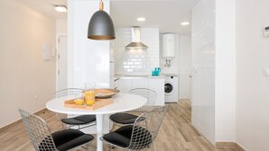 A modern kitchen with white cabinets, a built-in washing machine, and a water heater. - Spacious 5-Bedroom Apartment near Guadalmedina River, Málaga (Málaga)