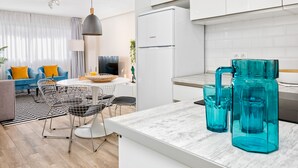 A modern kitchen with white cabinets, a black refrigerator, and a dining area with a white table and chairs. - Spacious 5-Bedroom Apartment near Guadalmedina River, Málaga (Málaga)
