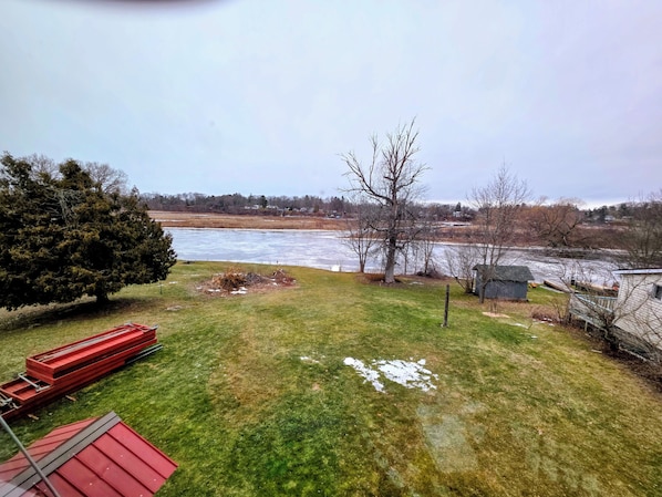 A grassy yard with a river, a large tree, and a small shed. - Riverside Vista: The perfect 3-bedroom apt in amazing Pulaski for your stay (Pulaski)