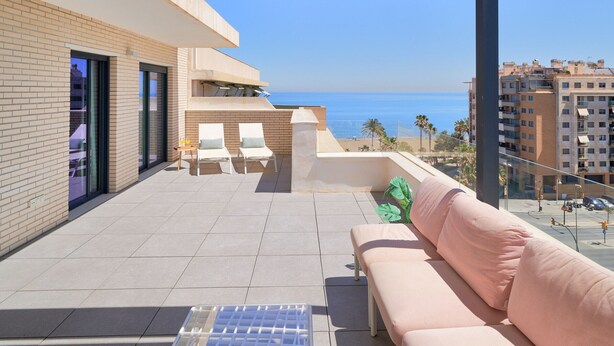 A balcony with a sofa, two chairs, and a table. - Chic 3-bedroom apartment with terrace, Wifi, and parking in Malaga (Málaga)
