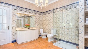 Een badkamer met een douche, toilet en wastafel.