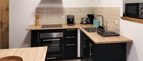 Een koelkast, een oven, een kookplaat, een koffiezetapparaat/waterkoker