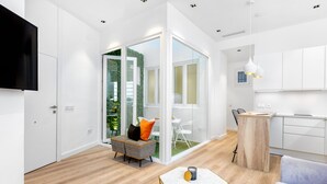 Una sala de estar moderna con un sofá, una mesa de centro y un comedor con sillas.