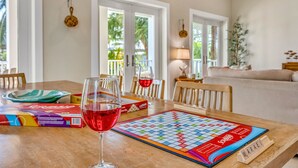 Een eettafel met een spel, wijnkansen en speldozen.
