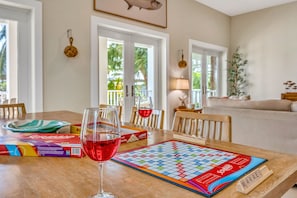 A dining table with a board game, wine glasses, and game boxes. - Water Views | Private Pool Oasis + Gazebo + Kayaks (Marathon)
