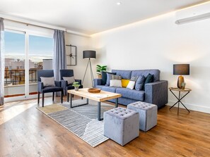 A modern living room with a grey sofa, two armchairs, a coffee table, and a side table with a lamp. - Elegant 2BR Apartment with Terrace in Central Málaga, Near Major Attractions (Málaga)