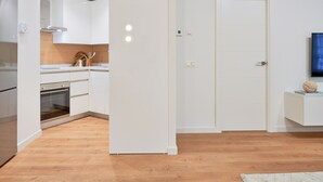 A modern kitchen with white cabinets, a wooden countertop, and a built-in oven. - Charming 2-Bedroom Apartment in Central Malaga with Modern Amenities (Málaga)
