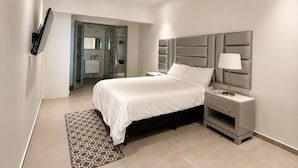 Une chambre à coucher moderne avec un lit, une table de chevet et un téléviseur intégré.