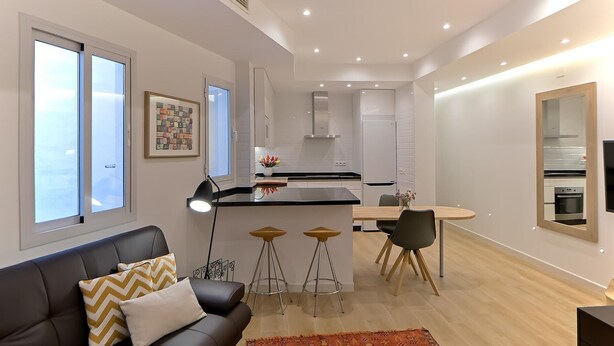 Un appartement moderne comprenant un espace de vie, un coin repas et une cuisine.