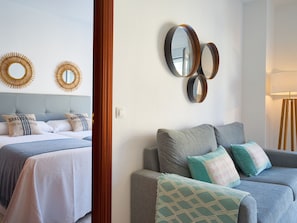 Ein Hotelzimmer mit einem Bett, einer Couch und wandmontierten Spiegeln.