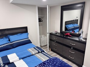 A bedroom with a bed, a dresser, a mirror, and a walk-in closet. - Perfect Location: Warm, Charming Basement (Mississauga)