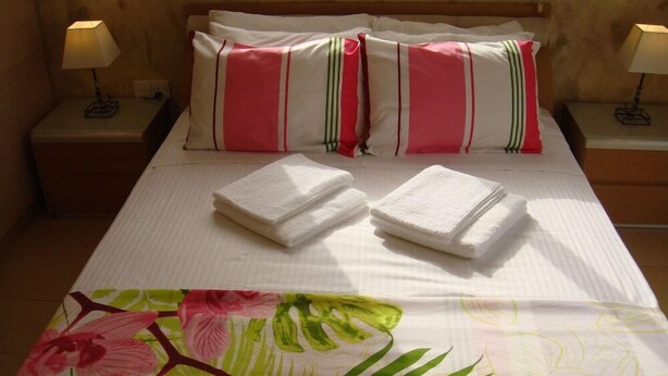 A hotel room with a bed, two nightstands, and a floral bedspread. - Athena Villa (Ayia Napa)