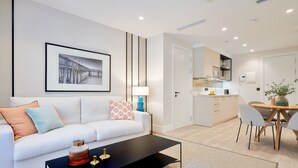Een modern appartement met een woonruimte, een eettafel en een keuken.