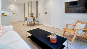 Een moderne woonkamer met een zwarte salontafel, een houten stoel en een eethoek met een tafel en stoelen.