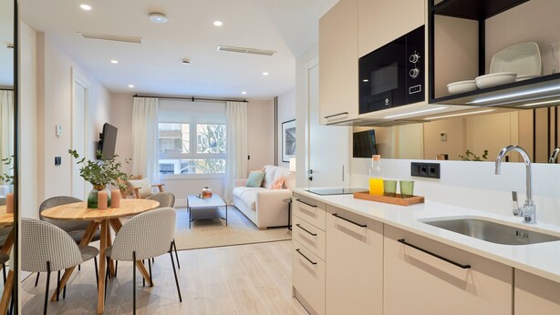 Een moderne keuken met een centraal kookeiland, een ingebouwde magnetron en een grote spoelbak.