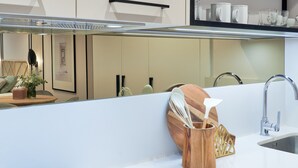 A modern kitchen with a white countertop, a stainless steel sink, and a wooden utensil holder. - Comfortable studio in La Malagueta with air conditioning and WiFi, near Malaga port (Málaga)