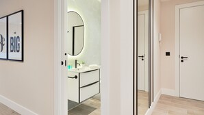 A modern bathroom with a white vanity, a round mirror, and a hexagonal tile backsplash. - Comfortable studio in La Malagueta with air conditioning and WiFi, near Malaga port (Málaga)