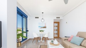 Ein modernes Wohnzimmer mit einer Couch, einem Couchtisch und einem Essbereich mit Stühlen und einem Tisch.