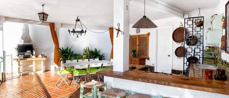 A spacious kitchen with a bar area, a dining table, and a grill.