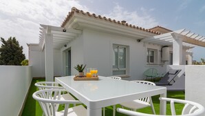 A white outdoor dining area with a table and chairs, a small potted plant, and a tray with a glass of orange juice. - Top-Floor Apartment Elegance in Carihuela, Torremolinos with Pool and Terrace (Torremolinos)