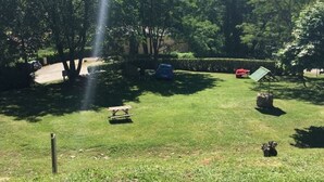 A grassy outdoor area with a picnic table, a small statue, and a bench. - Mobile home with terrace - 4 guests (Saint-Girons)
