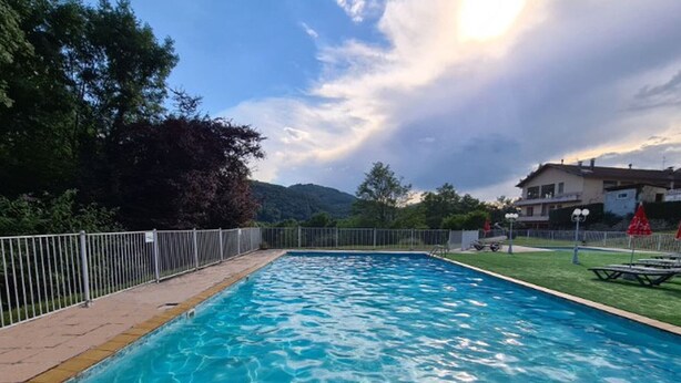 A rectangular swimming pool with clear blue water, surrounded by a white fence and a grassy area. - Mobile home with terrace - 4 guests (Saint-Girons)