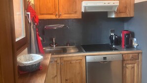 A compact kitchen with wooden cabinets, a Bosch dishwasher, a stove, and a coffee maker. - 3-room apartment for 6 people in Combloux (Combloux)