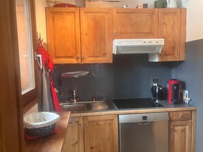 A compact kitchen with wooden cabinets, a Bosch dishwasher, a stove, and a coffee maker. - 3-room apartment for 6 people in Combloux (Combloux)