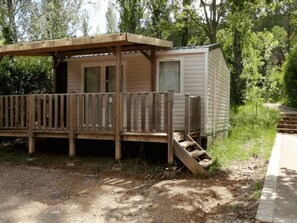 A small wooden cabin with a deck, a window, and a door. - Cozy Mobile Home for 4, Great Terrace (Villecroze)