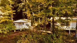 Un bâtiment de style cabane, entouré d’une forêt dense.