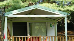 Une petite construction à un seul étage, dotée d’un toit végétalisé et d’une terrasse en bois.