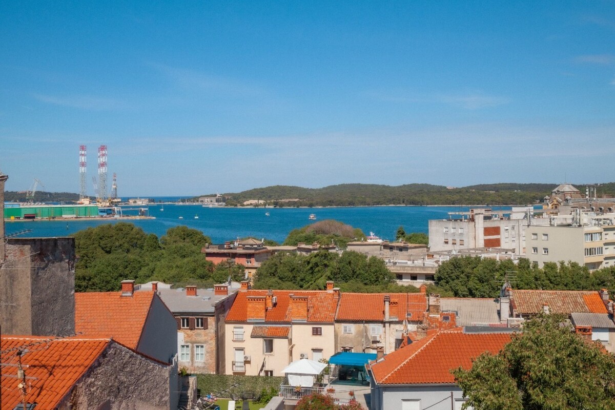 Eine Küstenstadt mit Gebäuden, einem Hafen und blauem Himmel.