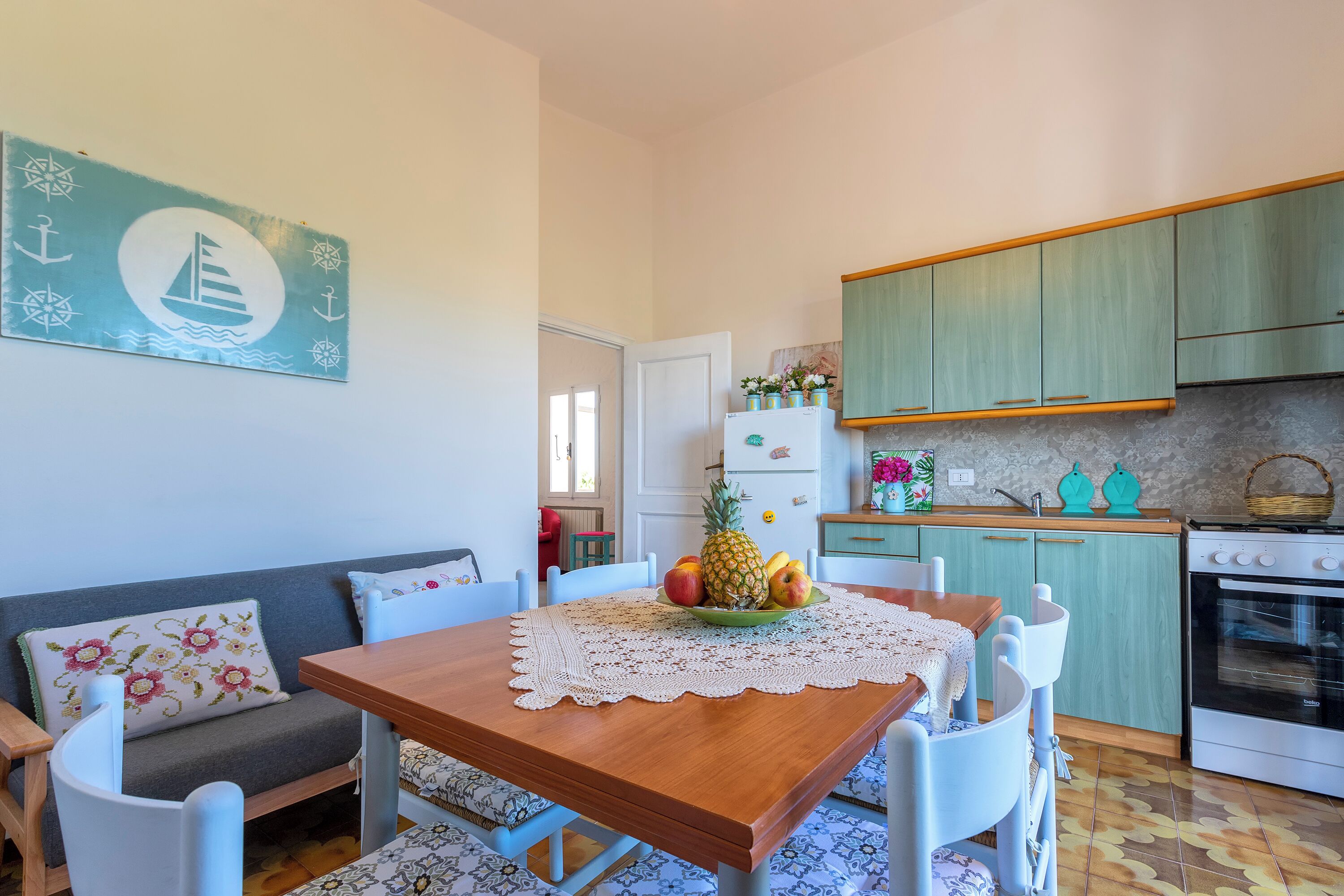 Une cuisine chaleureuse avec une table à manger, des chaises et un réfrigérateur.