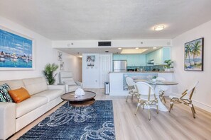 Ein modernes Wohnzimmer mit einer Couch, einem Couchtisch und einem Essbereich mit Stühlen.